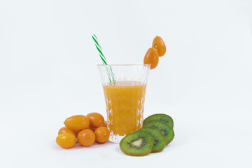 Green kiwi slices, orange juice and small oranges on a white background