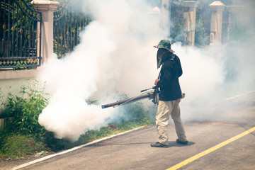 Obraz premium man use fumigation mosquitoes machine for kill mosquito carrier of Zika and dengue fever around the house