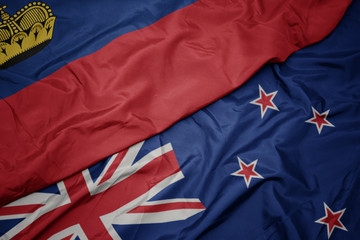 waving colorful flag of new zealand and national flag of liechtenstein.