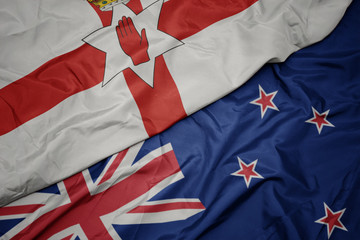 waving colorful flag of new zealand and national flag of northern ireland.