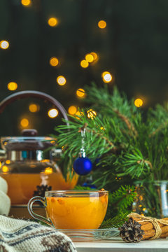 Christmas and New Year composition. Cup and teapot of hot spicy tea with sea buckthorn