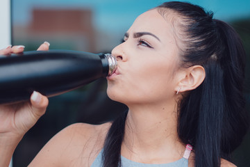 Woman taking break at gym drinking cool drink