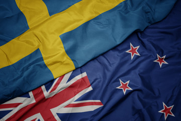 Fototapeta premium waving colorful flag of new zealand and national flag of sweden.