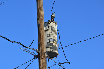 Isolated closeup of generic old rusty electric transformer on pole to signify the aging power grid
