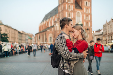Young loving couple hugs at central square in Krakow (Cracow).