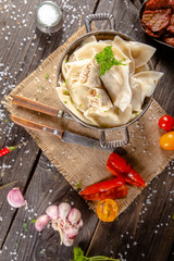 dumplings made of red and white fish meat, in a vintage rustic bowl plate, fork knife spoon, salt,...