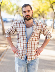 Portrait of an attractive man standing on street in a plaid shirt