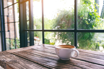Fototapeta na wymiar A white mug of hot coffee on wooden table in the morning