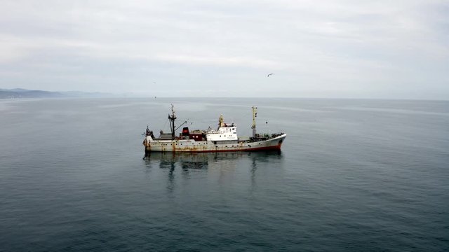 Fishingboat preparing return to shore with seagulls