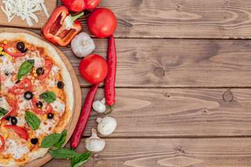 Pizza Margherita or Margarita with Mozzarella cheese, tomato, olive. Italian pizza on wooden background