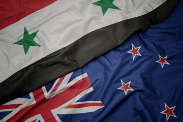 waving colorful flag of new zealand and national flag of syria.