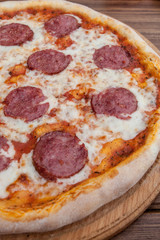 Italian Pepperoni pizza with salami on dark wooden background top view. Italian traditional food. Popular street food