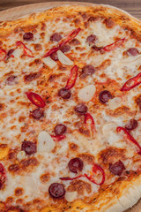 Pizza Restaurant Menu - Delicious Spicy Pizza with Sausages and Chili Pepper. Pizza on Rustic Wooden Table with Ingredients