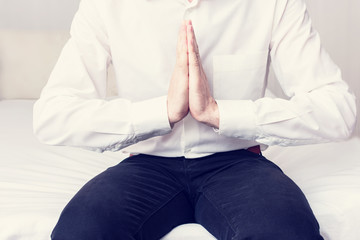 Office manager meditates before work, man's hands, cropped image, close up, toned