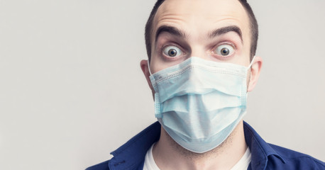 Stopped stunned man in a medical mask, portrait; close up, toned