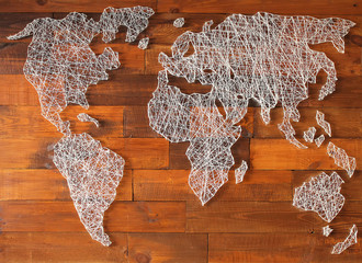 Decorative vintage map of the world made of threads and nails