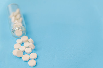 White pills and glass bottle on blue background. Alternative homeopathy is a herb medicine.The concept of health and medicine. Flatley. The view from the top. copyspace for text.