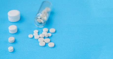 White pills and glass bottle on blue background. Alternative homeopathy is a herb medicine.The concept of health and medicine. Flatley. The view from the top. copyspace for text.