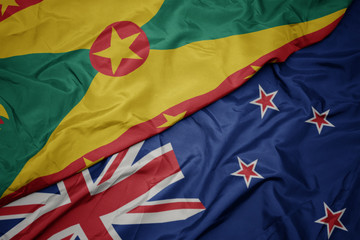 waving colorful flag of new zealand and national flag of grenada.