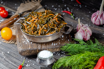 seaweed and carrot salad, mayonnaise sauce, in a rustic rustic bowl bowl, fork knife spoon, spices,...