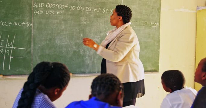 Female teacher at the blackboard in front of class 4k