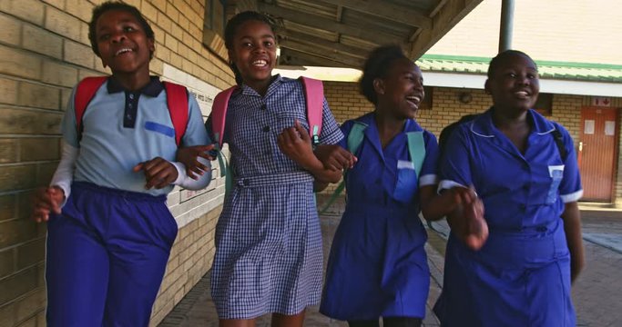 Schoolgirls running in the playground at a township school 4k