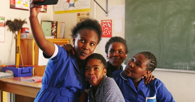 Schoolgirls taking selfies during a break at a township school 4k
