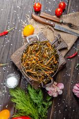 seaweed and carrot salad, mayonnaise sauce, in a rustic rustic bowl bowl, fork knife spoon, spices,...