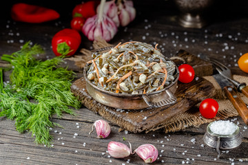 seaweed and carrot salad, mayonnaise sauce, in a rustic rustic bowl bowl, fork knife spoon, spices,...