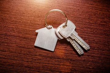 The symbol of the house lies on a brown wooden background 