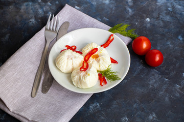 Poached egg - with slices of chili pepper, a sprig of dill, cherry tomatoes. For a healthy breakfast or snack. The plate lies on a gray napkin, there are cutlery. Fork and knife. 