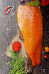 a large piece of red fish fillet with vegetables and spices and fresh herbs, stand and lie, from...