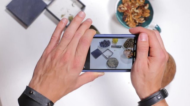 blogger takes photos of food and marijuana on a smartphone, healthy eating