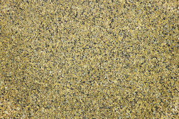 The background of polished granite in yellow black shades. A background for design and creative work. Decoration and exterior decoration of the building. Construction works