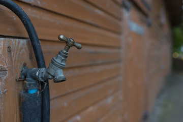 old tap outside of wooden door