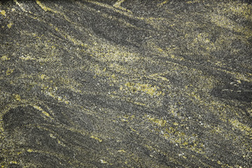 The plate is made of marble of yellowish-black shades. Smooth texture for design and decoration. Natural building material. Natural patterns on the stone. Plates for floor and walls