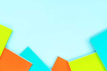 Multicolored school notebooks on a pastel sky blue background. Concept back to school. Minimalism flat lay