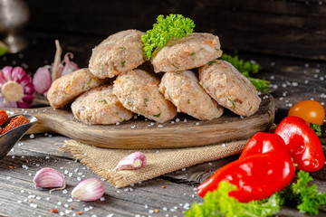 homemade meatballs, cutlets raw from red and white fish meat, in a vintage rustic plate bowl, fork...