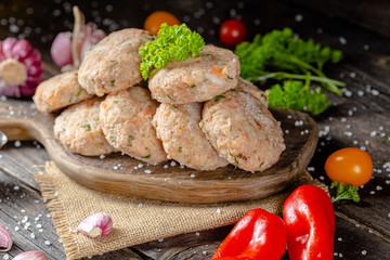 homemade meatballs, cutlets raw from red and white fish meat, in a vintage rustic plate bowl, fork...