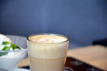  Aromatic coffee with a pattern in a glass cup on a brick wall background.