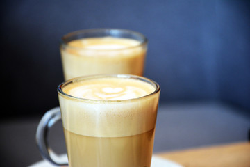  Aromatic coffee with a pattern in a glass cup on a brick wall background.