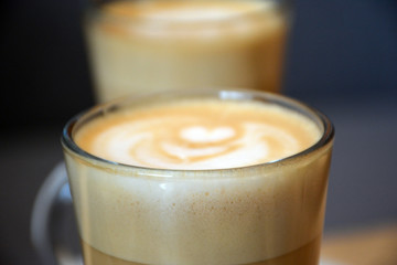  Aromatic coffee with a pattern in a glass cup on a brick wall background.