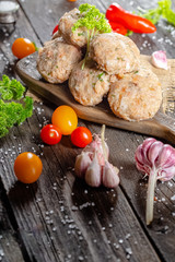 homemade meatballs, cutlets raw from red and white fish meat, in a vintage rustic plate bowl, fork...