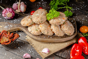 homemade meatballs, cutlets raw from red and white fish meat, in a vintage rustic plate bowl, fork...