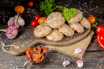 homemade meatballs, cutlets raw from red and white fish meat, in a vintage rustic plate bowl, fork...