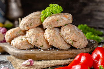 homemade meatballs, cutlets raw from red and white fish meat, in a vintage rustic plate bowl, fork...