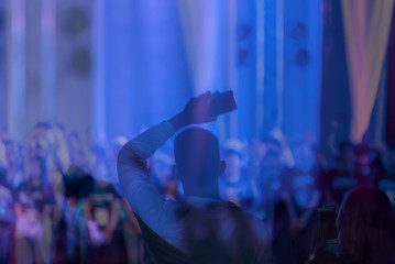 Silhouette image and Defocused of entertainment concert colorfull lighting on stage,Audience taking photos of artist,blurred Live Concert and disco party.