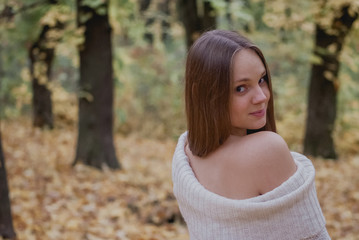 Naklejka premium Portrait of a beautiful, dreamy and happy girl with long wavy hair in knit sweater autumn. Nice weather