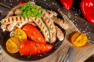 homemade hotdog sausages fried from red and white fish meat, in a vintage rustic plate bowl, fork...