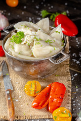 dumplings made of red and white fish meat, in a vintage rustic bowl plate, fork knife spoon, salt,...